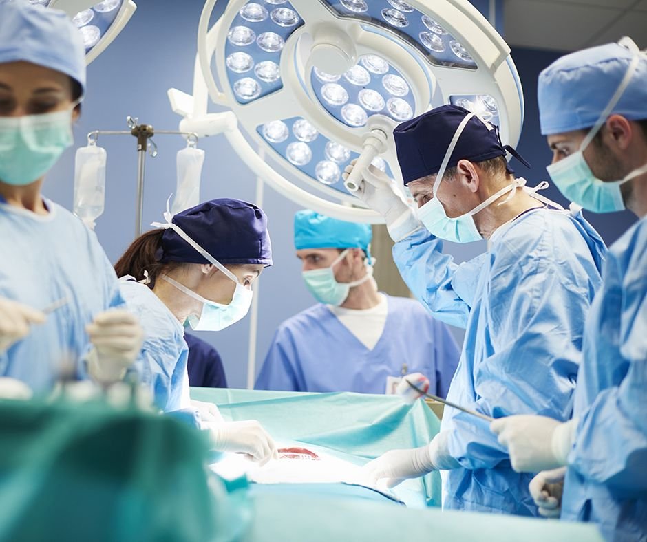 Surgeons in an operating room looking at a patient during surgery.