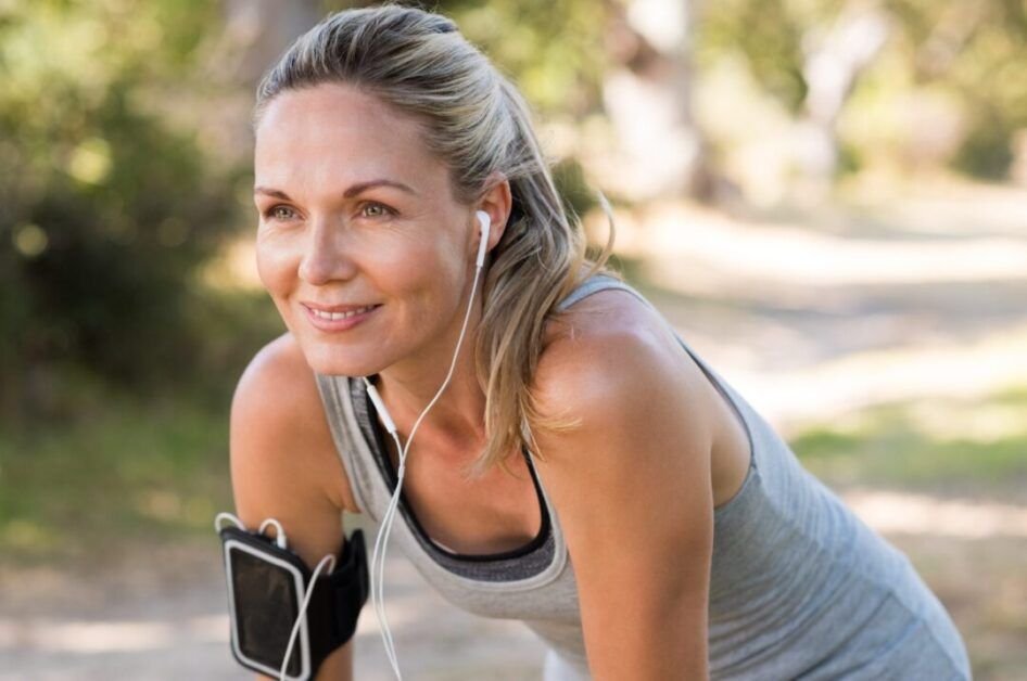 Confident woman outdoors after workout, symbolizing strength and recovery